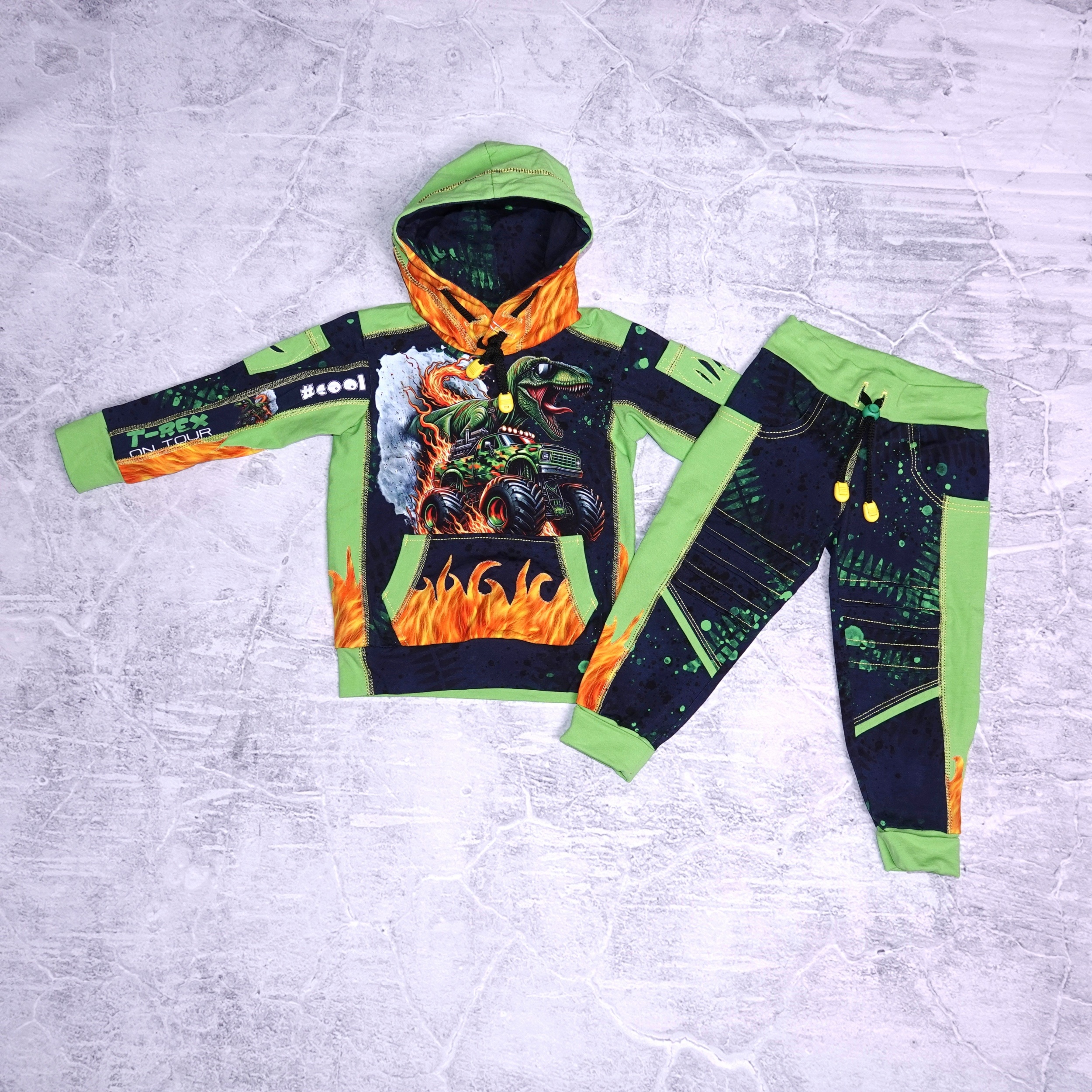 Dinosausus op een monstertruk set oversized hoody met buidelzak en stoere vlam details . Broek met moto patches en vlammen details maat 3 jaar (98)