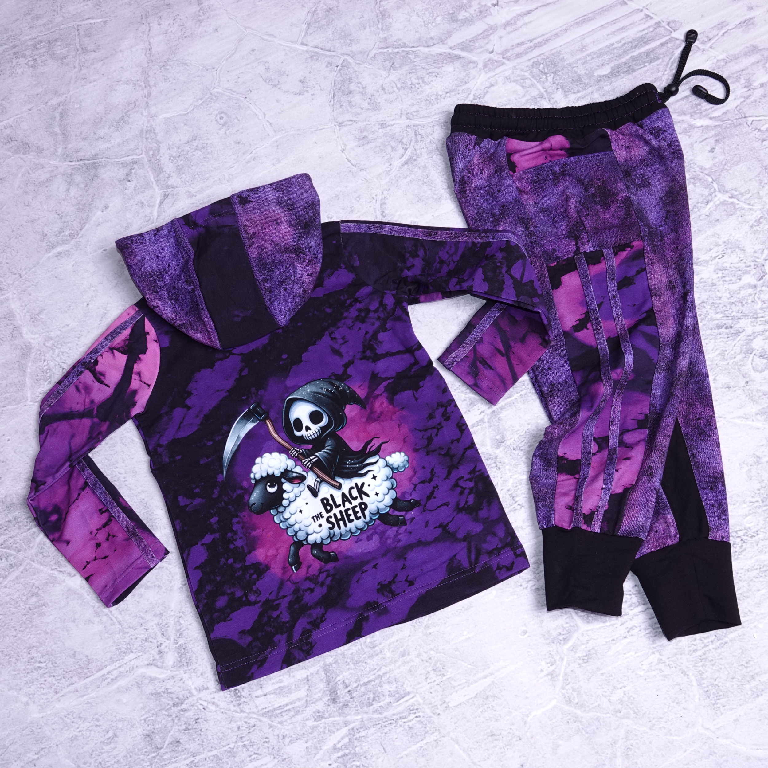 Joggingset snap jasje met druk knoopjes met blacksheep print ( grim reaper die op een schaap rijd ) en joggers kleur paars met zwart maat 122 (7jaar)