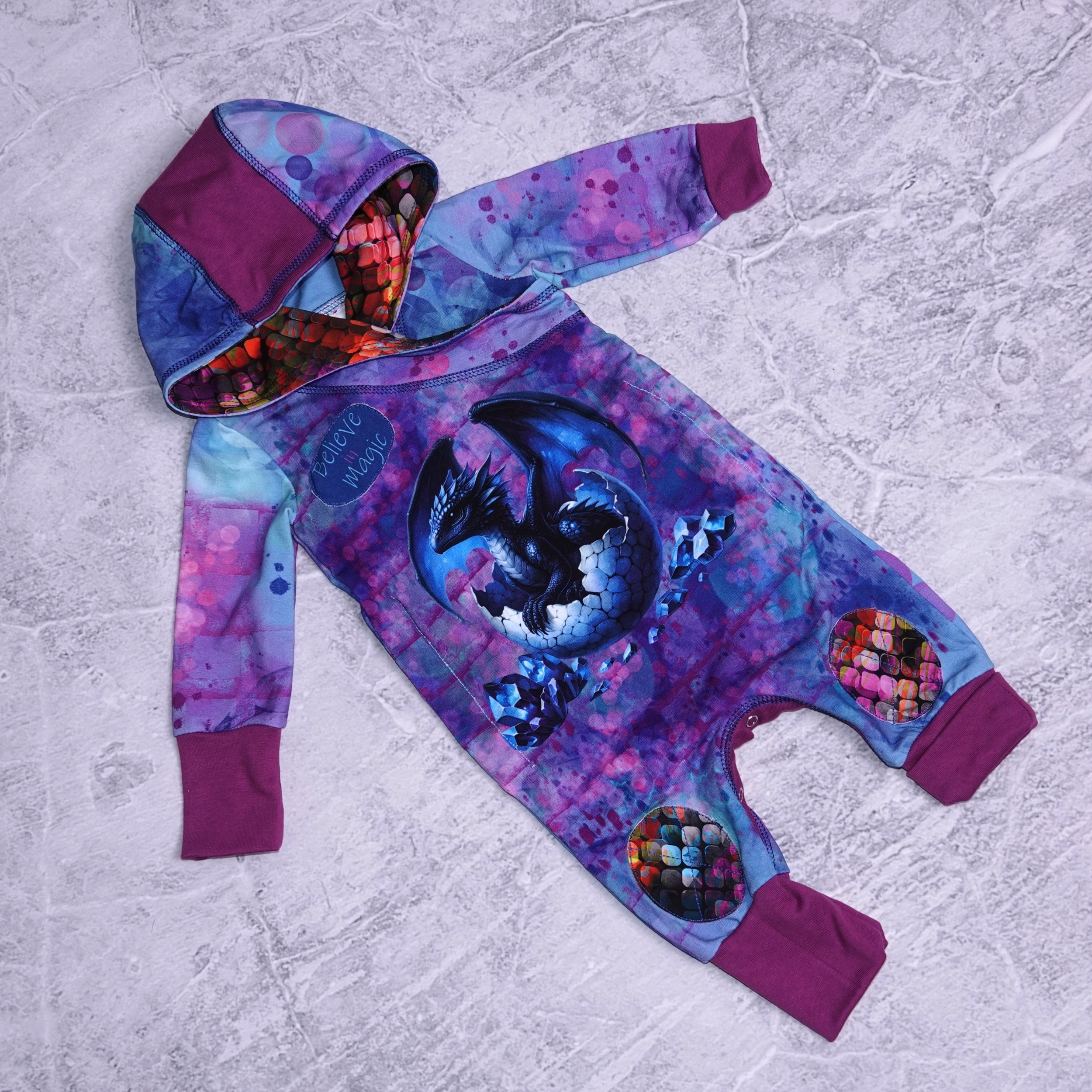 Babymeegroeipakje met babydraakje print , knie stukken en druk knoopjes tussen de benen .Dit pakje groeit mee met de baby van 0-1 jaar